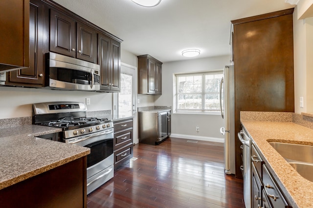 kitchen with dark hardwood / wood-style flooring, dark brown cabinets, and stainless steel appliances