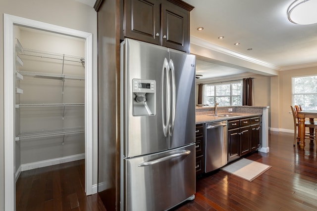 kitchen with dark wood-type flooring, appliances with stainless steel finishes, plenty of natural light, and dark brown cabinets