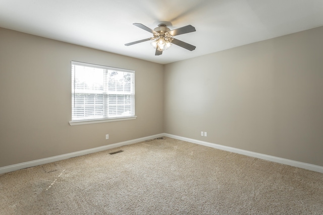 carpeted spare room featuring ceiling fan