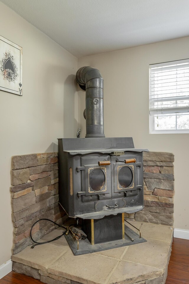 details with a wood stove and hardwood / wood-style floors