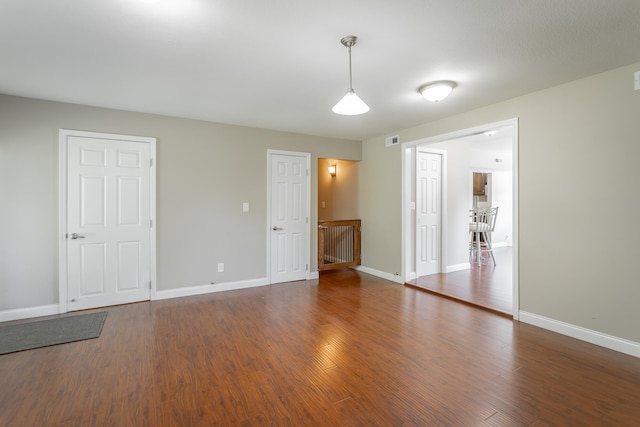 unfurnished room featuring dark wood-type flooring