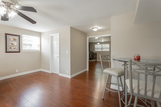 dining room with dark wood-type flooring, a healthy amount of sunlight, and ceiling fan