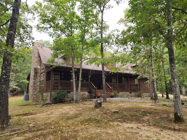 rear view of house with a deck and central AC