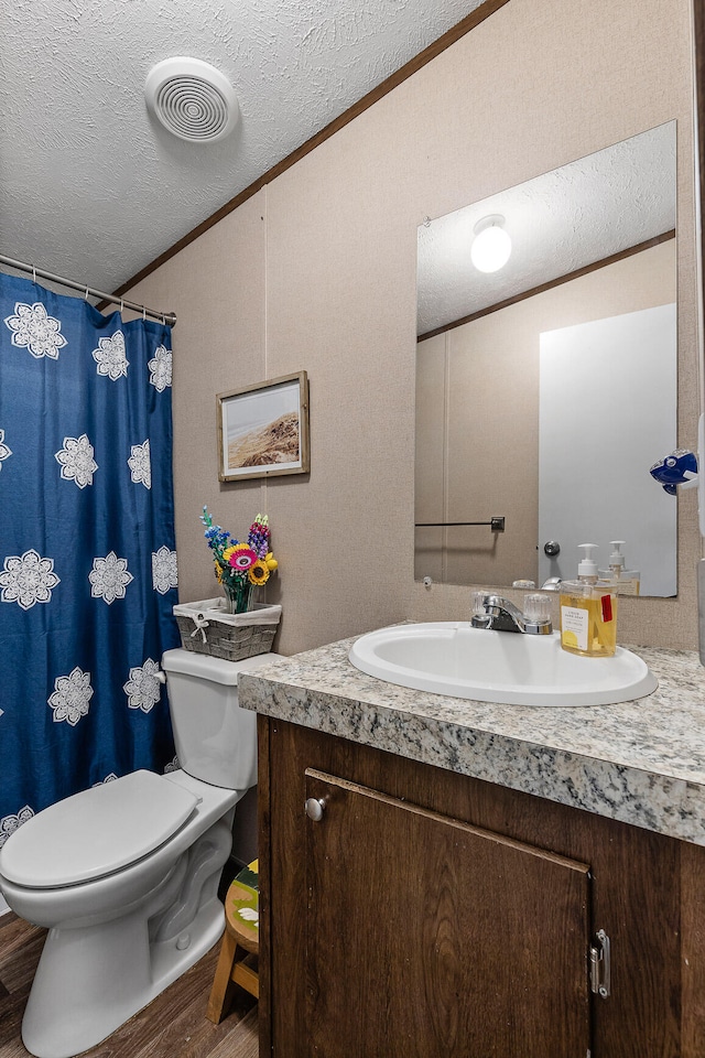 bathroom with hardwood / wood-style floors, crown molding, vanity, and toilet