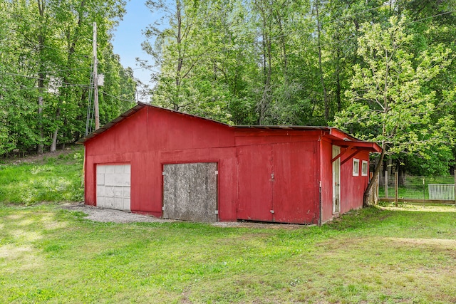 view of outdoor structure featuring a garage and a lawn