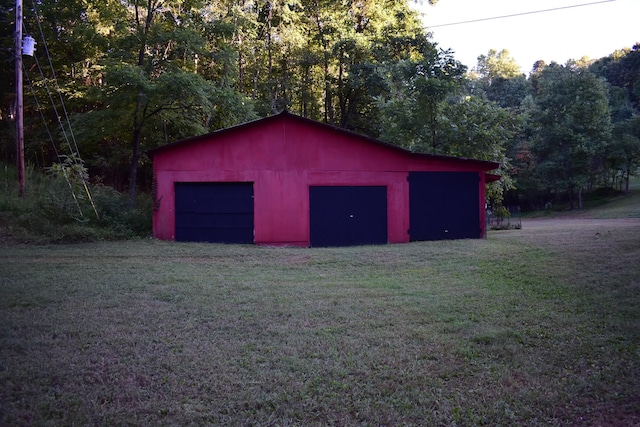 view of outbuilding featuring a lawn and a garage