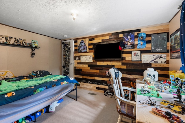 bedroom featuring wood walls and a textured ceiling