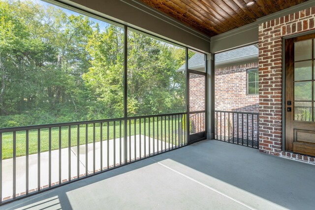 unfurnished sunroom with wood ceiling and plenty of natural light