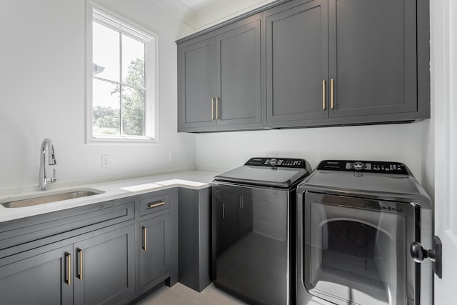 laundry area featuring washer and clothes dryer, sink, and cabinets