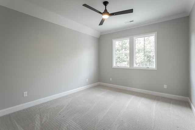 empty room featuring ceiling fan, light colored carpet, lofted ceiling, and ornamental molding