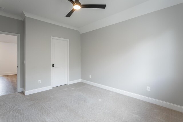 unfurnished bedroom featuring ceiling fan, light carpet, and ornamental molding