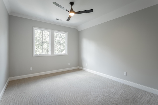 spare room featuring carpet floors, crown molding, lofted ceiling, and ceiling fan