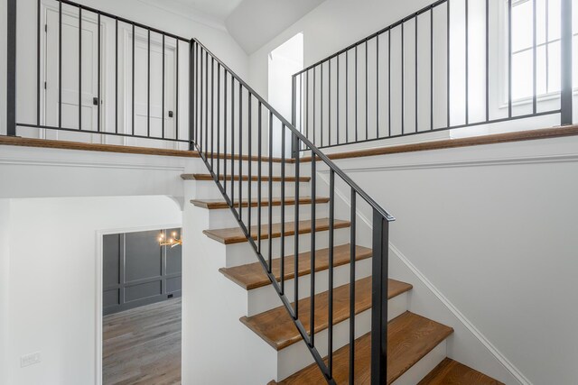 stairway with a chandelier and hardwood / wood-style flooring