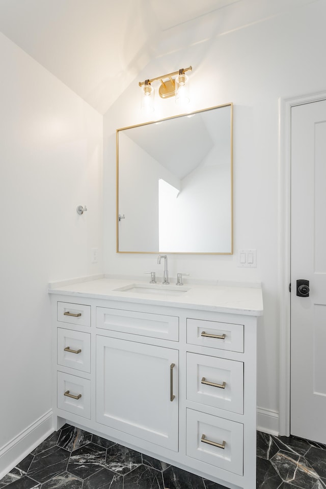 bathroom with vaulted ceiling and vanity