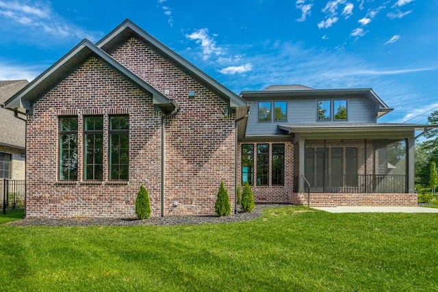 back of property with a lawn and a sunroom