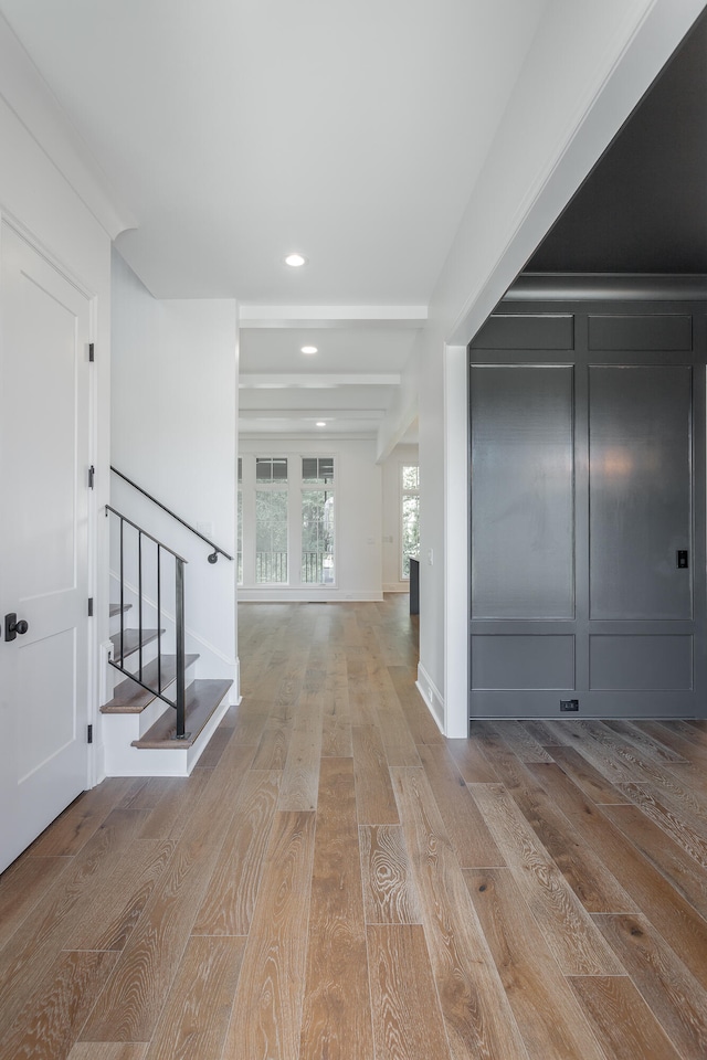 foyer entrance featuring beam ceiling and light hardwood / wood-style floors