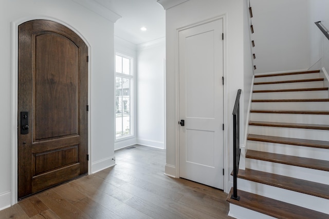 foyer entrance with ornamental molding and light hardwood / wood-style flooring