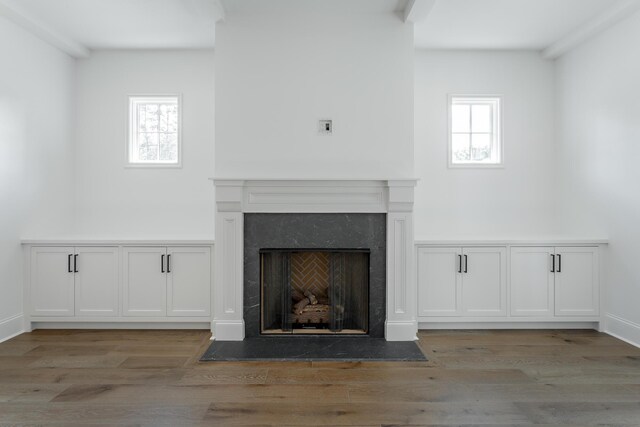 details with beamed ceiling, hardwood / wood-style floors, and a high end fireplace