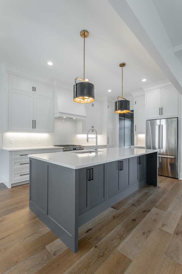 kitchen featuring a large island, appliances with stainless steel finishes, light hardwood / wood-style floors, and white cabinetry