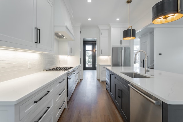 kitchen with pendant lighting, dark hardwood / wood-style floors, a kitchen island with sink, white cabinetry, and stainless steel appliances