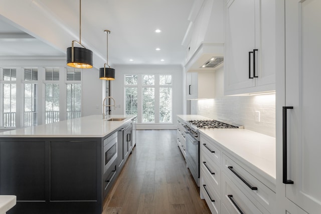 kitchen featuring an island with sink, white cabinetry, sink, and stainless steel appliances