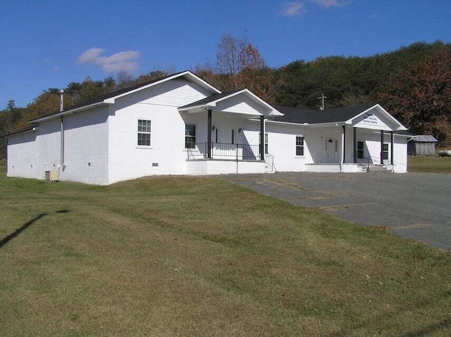 view of front facade featuring covered porch, a front lawn, and cooling unit