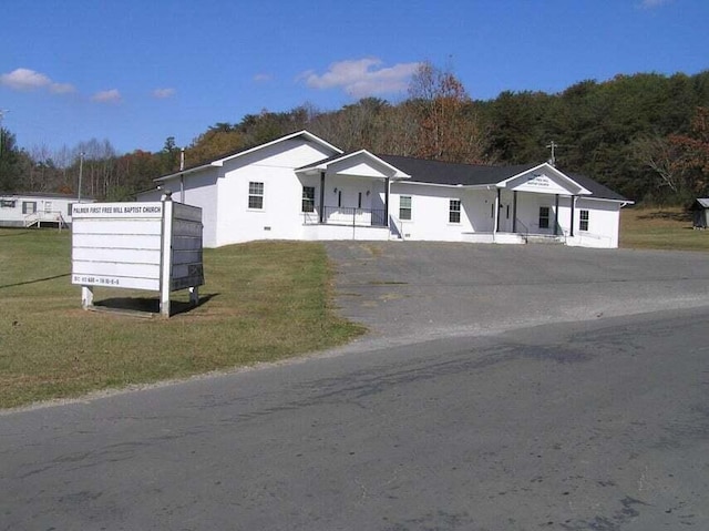 ranch-style house featuring covered porch and a front lawn