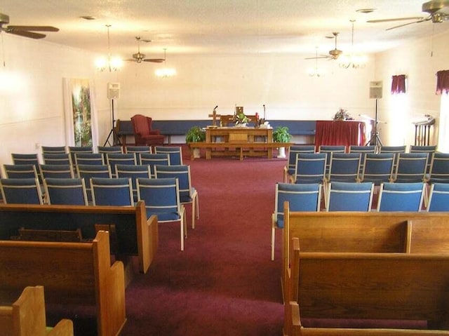 interior space with a textured ceiling, ceiling fan, and carpet flooring