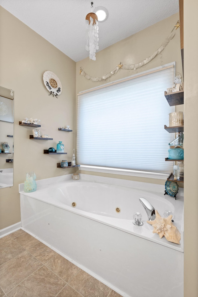 bathroom with a bathing tub, tile patterned flooring, and a textured ceiling