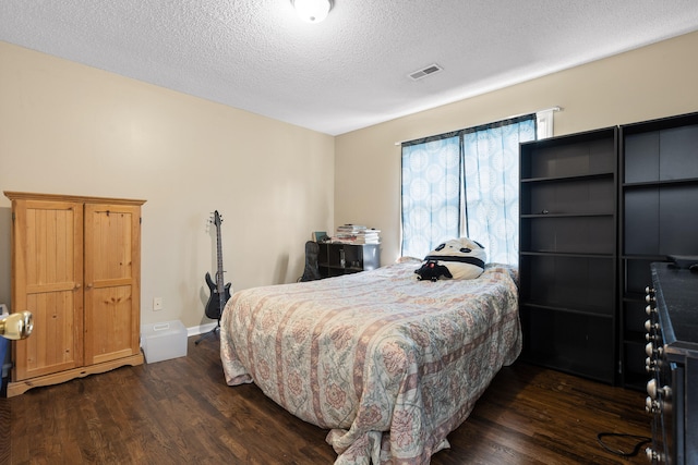 bedroom featuring a textured ceiling and dark wood-type flooring