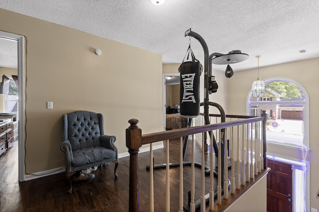 corridor featuring a textured ceiling and dark hardwood / wood-style flooring