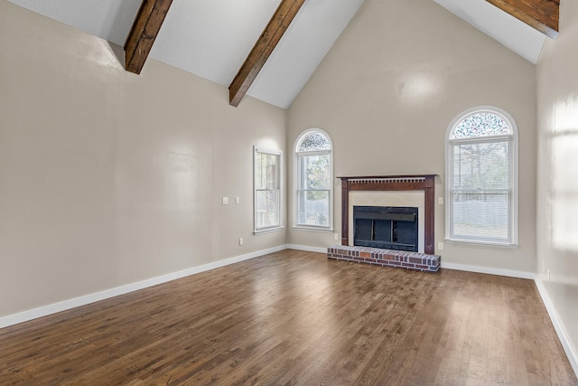 unfurnished living room featuring beamed ceiling, a healthy amount of sunlight, wood-type flooring, and high vaulted ceiling