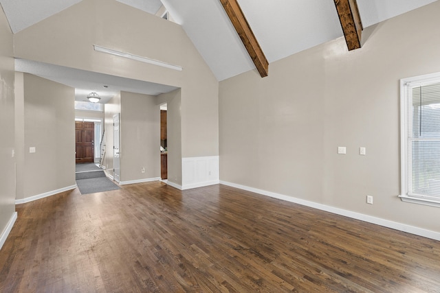 unfurnished living room featuring beam ceiling, dark hardwood / wood-style flooring, high vaulted ceiling, and a healthy amount of sunlight