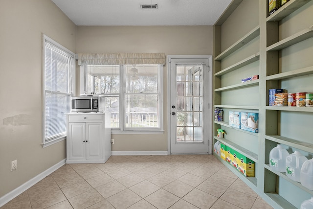 entryway featuring light tile patterned floors and a textured ceiling