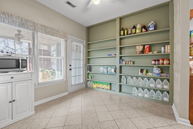 interior space with ceiling fan, light tile patterned floors, and a textured ceiling