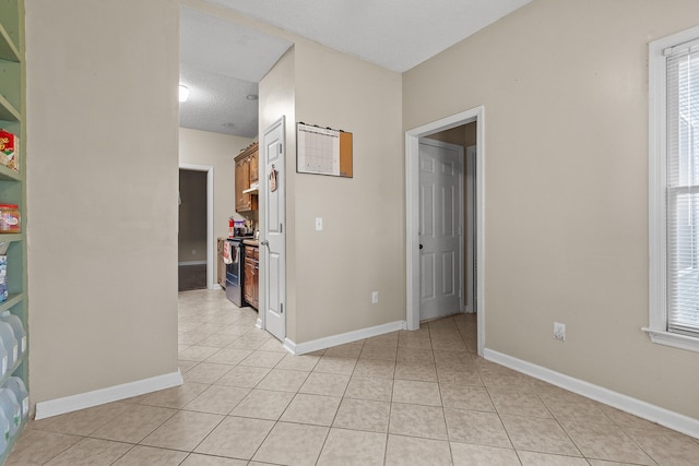 interior space with plenty of natural light, light tile patterned floors, and a textured ceiling