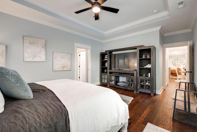 bedroom featuring a raised ceiling, ornamental molding, ceiling fan, and dark wood-type flooring