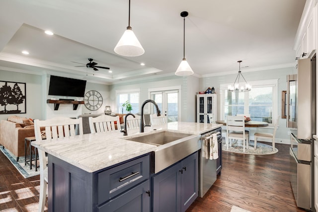 kitchen featuring ceiling fan with notable chandelier, dark hardwood / wood-style floors, appliances with stainless steel finishes, and pendant lighting