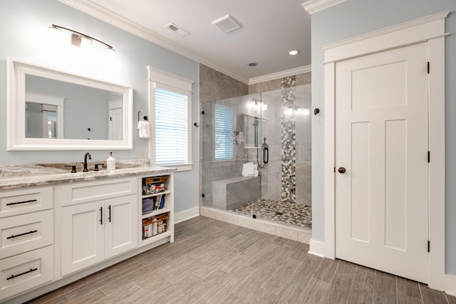 bathroom with ornamental molding, vanity, and a shower with shower door