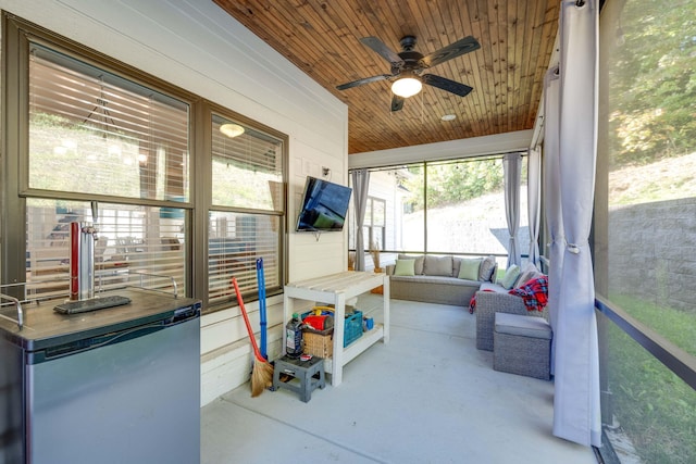 sunroom featuring ceiling fan and wooden ceiling