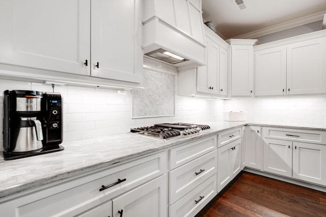 kitchen with decorative backsplash, white cabinets, stainless steel gas cooktop, and dark wood-type flooring