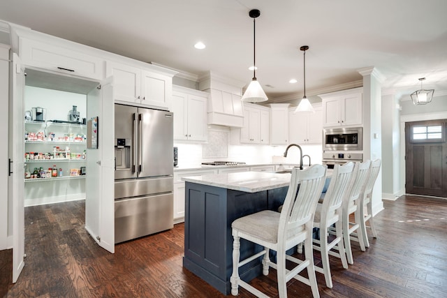 kitchen with stainless steel appliances, white cabinetry, dark wood-type flooring, and a kitchen island with sink