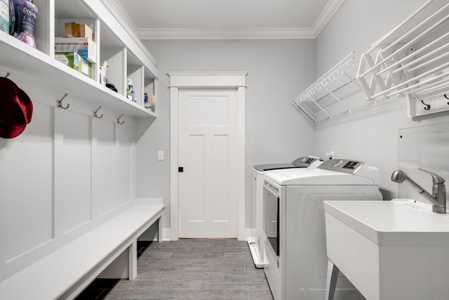 washroom featuring ornamental molding, washing machine and dryer, hardwood / wood-style flooring, and sink