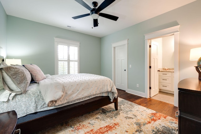 bedroom featuring light hardwood / wood-style floors, ensuite bath, and ceiling fan