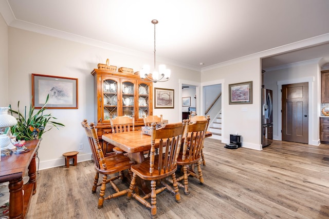 dining area with wood-type flooring, a chandelier, and ornamental molding