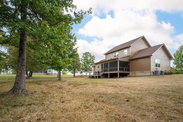 back of property featuring a lawn, cooling unit, and a sunroom