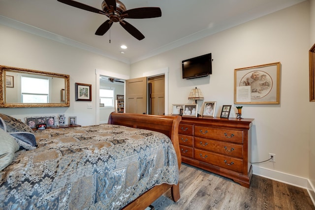 bedroom featuring wood-type flooring, multiple windows, ceiling fan, and crown molding