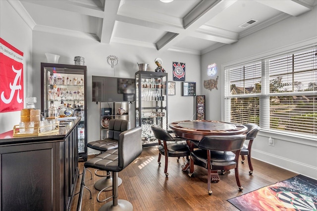 dining space featuring bar area, wood-type flooring, and coffered ceiling