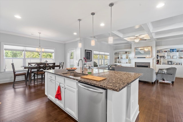 kitchen with dark stone countertops, a tile fireplace, dishwasher, ceiling fan, and white cabinets