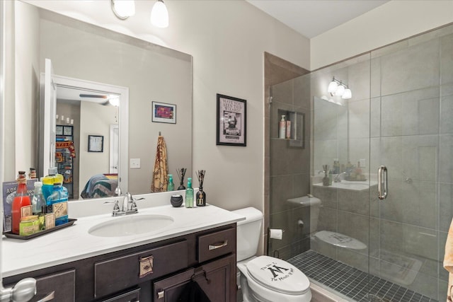 bathroom with a shower with shower door, toilet, and vanity